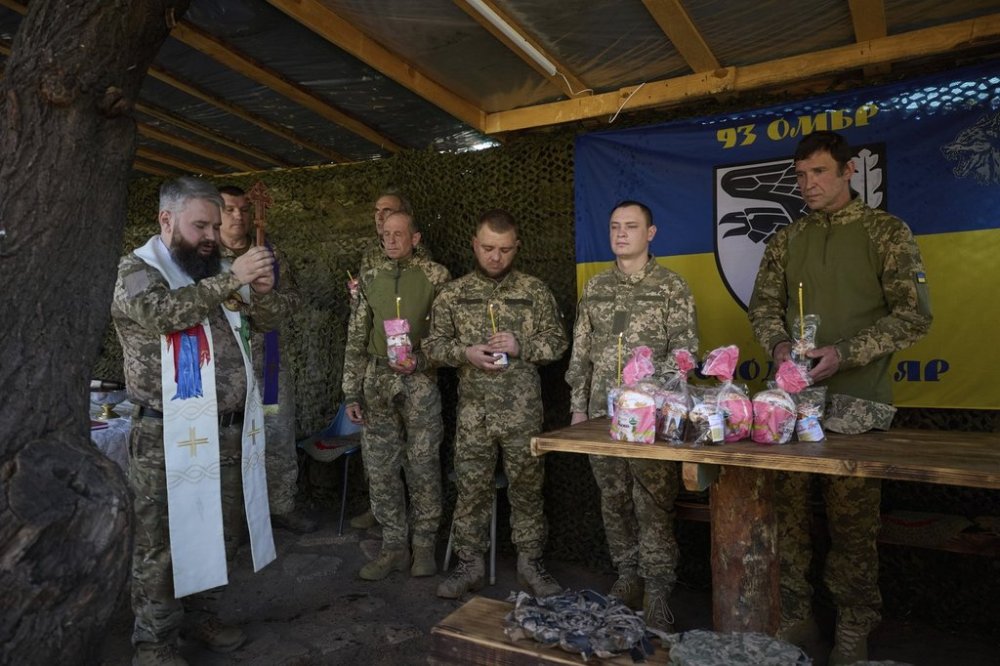 In this photo provided by Ukraine's 93rd Kholodnyi Yar Separate Mechanized Brigade press service, Ukrainian servicemen attend an Easter service on their position in the Donetsk region, Ukraine, Sunday, April 20, 2025. (Mykola Oliinyk/Ukraine's 93rd Mechanized Brigade via AP)