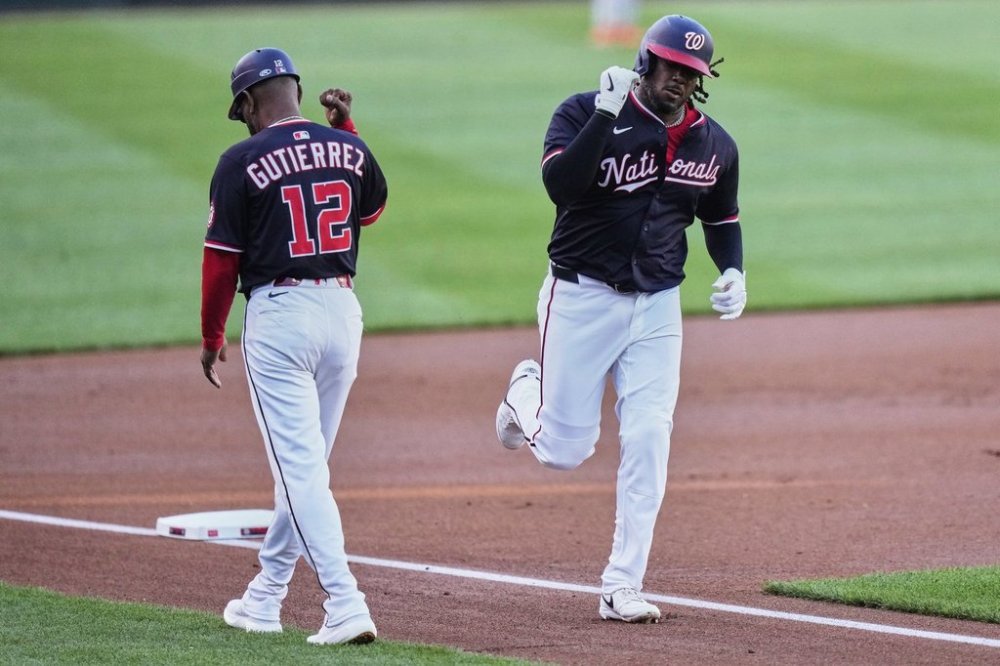 Washington Nationals' Josh Bell, right, celebrates with third base coach Ricky Gutierrez (12) after hitting a two-run home run during the first inning of a baseball game against the Baltimore Orioles, Wednesday, April 23, 2025, in Washington. (AP Photo/Stephanie Scarbrough)