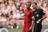 Referee Bastian Dankert, right, speaks with Bayern's Harry Kane during the German Bundesliga soccer match between Bayern Munich and 1. FSV Mainz 05 at the Allianz Arena in Munich, Germany, Saturday, April 26, 2025. (AP Photo/Matthias Schrader)