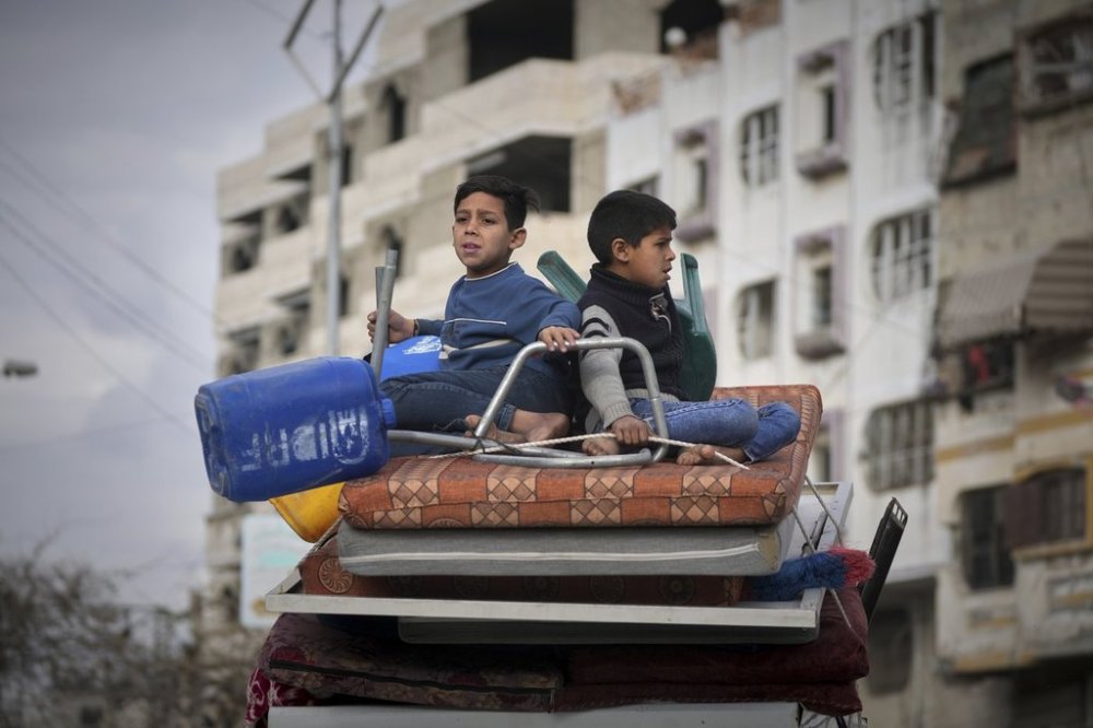 Two boys sit on a mattress as they ride on their family car while s fleeing from east to west of Gaza City after the Israeli military issued evacuation orders in the area, Friday April 11, 2025. (AP Photo/Jehad Alshrafi)