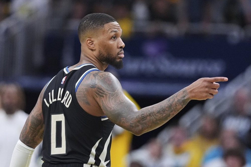 Milwaukee Bucks guard Damian Lillard (0) gestures after a three-point basket against the Indiana Pacers during the second half of a first-round NBA basketball playoff game in Indianapolis, Tuesday, April 22, 2025. (AP Photo/Michael Conroy)