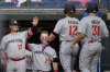 Minnesota Twins' Harrison Bader (12) and Jonah Bride (31) are greeted by teammates Ty France (13) and Ryan Jeffers (27) as they return to the dugout after scoring on a single hit by Byron Buxton in the second inning of a baseball game against the Cleveland Guardians in Cleveland, Monday, April 28, 2025. (AP Photo/Sue Ogrocki)