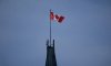 The Canadian flag flies over the Peace Tower on Parliament Hill, Friday, Feb. 14, 2025 in Ottawa. THE CANADIAN PRESS/Adrian Wyld