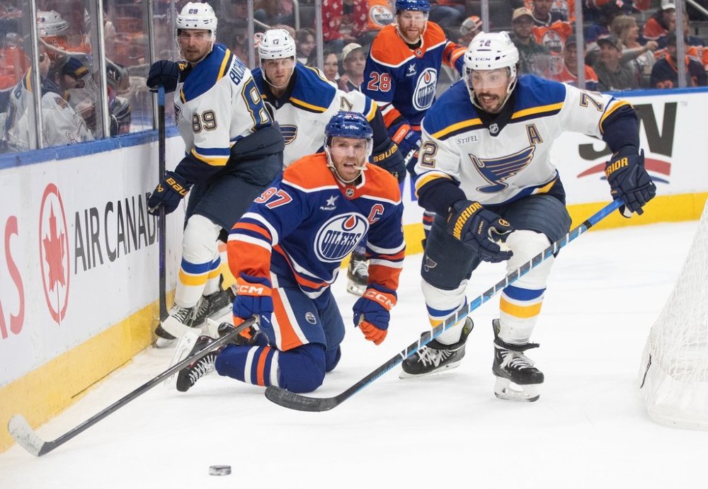 St. Louis Blues' Justin Faulk (72) and Edmonton Oilers' Connor McDavid (97) battle for the puck during second period NHL action in Edmonton on Wednesday, April 9, 2025. THE CANADIAN PRESS/Jason Franson