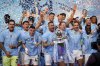 FILE — Manchester City's Kyle Walker celebrates with the Premier League trophy after the English Premier League soccer match between Manchester City and West Ham United at the Etihad Stadium in Manchester, England, Sunday, May 19, 2024. A fourth-straight Premier League title for Manchester City marks an unprecedented period of dominance by one team in English soccer. (AP Photo/Dave Thompson, File)