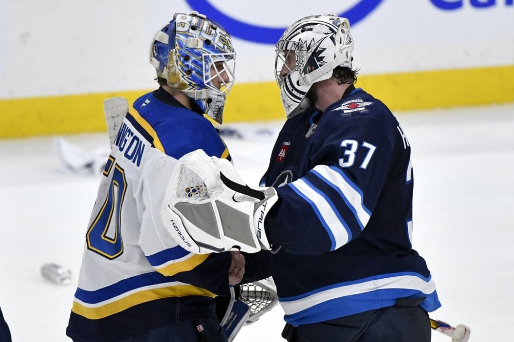 St. Louis Blues goaltender Jordan Binnington (50) shakes hands with Winnipeg Jets goaltender Connor Hellebuyck (37) after the Jets won in the second overtime period of NHL round one, game seven Stanley Cup playoff action in Winnipeg, Sunday May 4, 2025. THE CANADIAN PRESS/Fred Greenslade