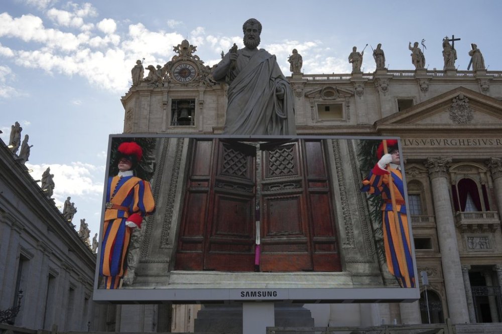 A giant screen in St Peter's Basilica shows a Vatican official closing the door to the Sistine Chapel after calling out