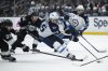 Winnipeg Jets centre Mark Scheifele (55) controls the puck past Los Angeles Kings left-winger Warren Foegele (37) during third period NHL hockey action, in Los Angeles, Tuesday, April 1, 2025. THE CANADIAN PRESS/AP-Kyusung Gong