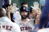 Houston Astros first baseman Christian Walker, center, collects high fives in the dugout after his solo home run against the Toronto Blue Jays during the second inning of a baseball game Wednesday, April 23, 2025, in Houston. (AP Photo/Michael Wyke)