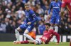 Liverpool's Curtis Jones, bottom, challenges Chelsea's Cole Palmer during the English Premier League soccer match between Chelsea and Liverpool at Stamford Bridge stadium in London, Sunday, May 4, 2025. (AP Photo/Kin Cheung)