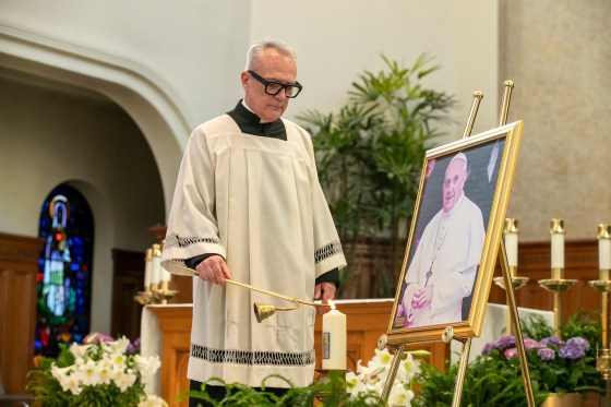 Rev. Darren Gurr of St. Gianna Beretta Molla Roman Catholic Church lights a candle that bears the coat of arms of Pope Francis at a memorial mass for the late pontiff at St. Mary’s Cathedral Wednesday. (Brook Jones / Free Press)