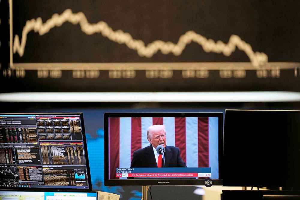 US President Donald Trump appears on a television screen at the stock market in Frankfurt, Germany, Thursday, April 3, 2025. (AP Photo/Michael Probst)
