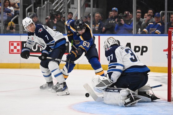 Winnipeg Jets' Connor Hellebuyck (37) and Vladislav Namestnikov (7) defend the net against St. Louis Blues' Jake Neighbours (63) in Game 4 on Sunday. (Connor Hamilton / The Associated Press files)