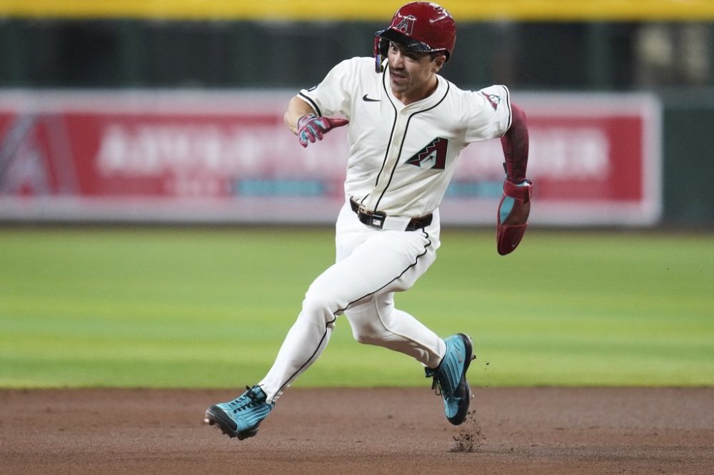 Arizona Diamondbacks' Corbin Carroll advances to third base on a single by Diamondbacks' Geraldo Perdomo against the Baltimore Orioles during the first inning of a baseball game Wednesday, April 9, 2025, in Phoenix. (AP Photo/Ross D. Franklin)