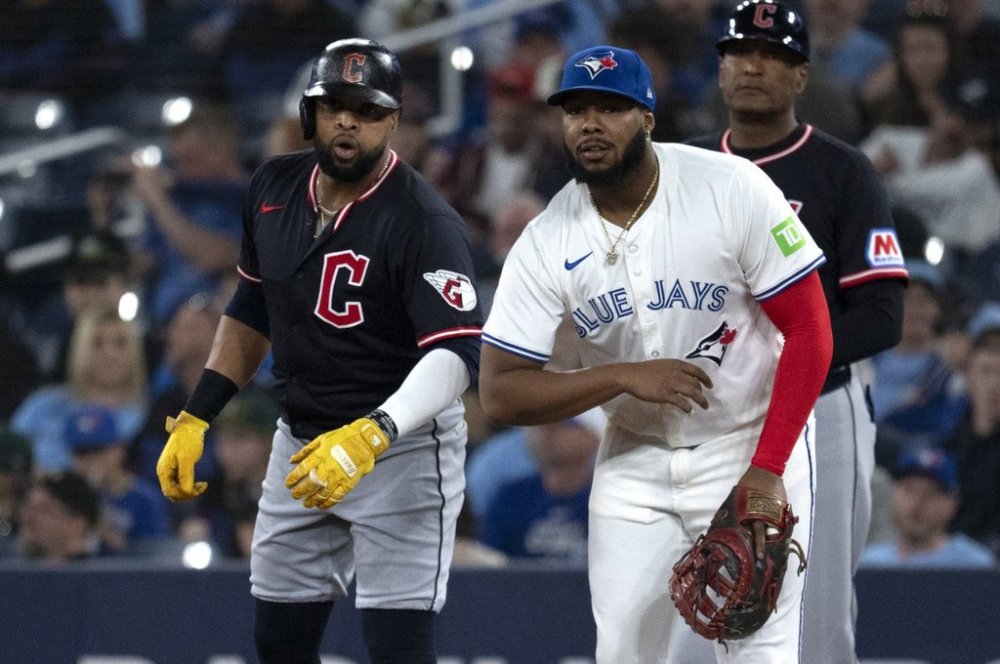 Cleveland Guardians first baseman Carlos Santana, left, jokes with Toronto Blue Jays first baseman Vladimir Guerrero Jr during first inning American League baseball action in Toronto on Saturday, May 3, 2025. THE CANADIAN PRESS/Jon Blacker