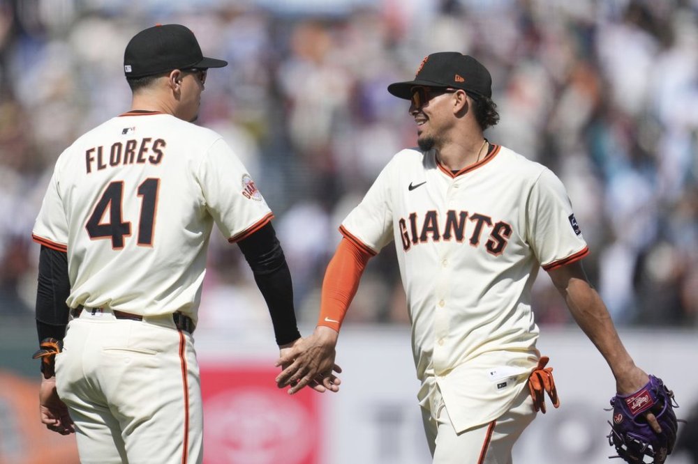 San Francisco Giants' Wilmer Flores (41) celebrates with Willy Adames after a baseball game against the Colorado Rockies in San Francisco, Sunday, May 4, 2025. (AP Photo/Jeff Chiu)