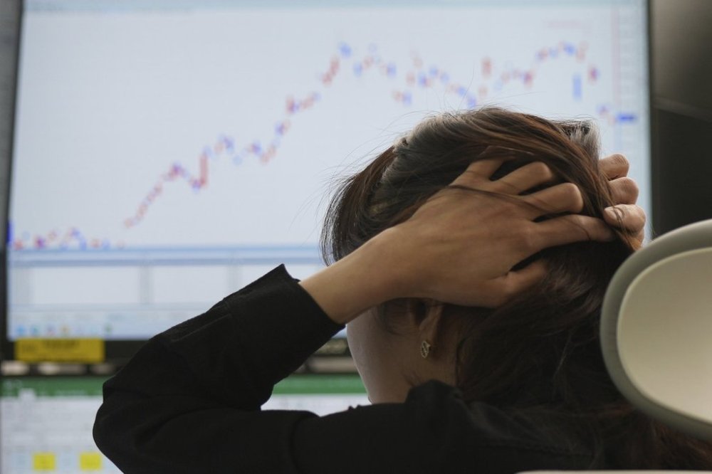 A dealer holds her hair at a dealing room of Hana Bank in Seoul, South Korea, Thursday, April 17, 2025. (AP Photo/Lee Jin-man)