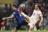 Munich's Harry Kane, right, and Inter's Francesco Acerbi fight for the ball during the Champions League quarterfinals first leg soccer match between FC Bayern Munich and Inter Milan, at the Allianz Arena in Munich, Germany, Tuesday, April 8, 2025. (Sven Hoppe/dpa via AP)