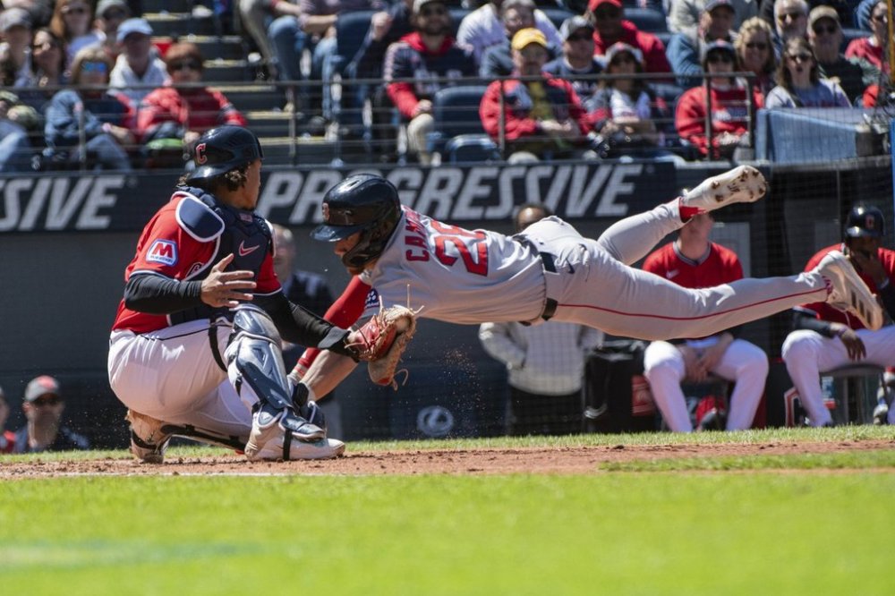 Boston Red Sox's Kristian Campbell, right, scores on a throwing error as Cleveland Guardians' Bo Naylor, left, is late with the tag during the second inning of a baseball game Sunday, April 27, 2025, in Cleveland. (AP Photo/Phil Long)