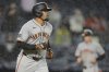 San Francisco Giants' LaMonte Wade Jr. head to first base as Mike Yastrzemski heads to home plate after Wade Jr. was walked with the bases loaded during the sixth inning of a baseball game Friday, April 11, 2025, in New York. (AP Photo/Frank Franklin II)