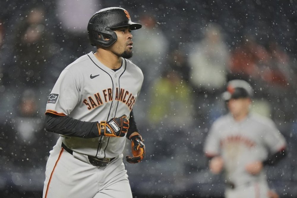 San Francisco Giants' LaMonte Wade Jr. head to first base as Mike Yastrzemski heads to home plate after Wade Jr. was walked with the bases loaded during the sixth inning of a baseball game Friday, April 11, 2025, in New York. (AP Photo/Frank Franklin II)