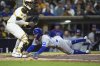 Chicago Cubs' Dansby Swanson, right, slides in to score off a sacrifice bunt by Pete Crow-Armstrong as San Diego Padres catcher Martin Maldonado waits for the throw during the sixth inning of a baseball game Tuesday, April 15, 2025, in San Diego. (AP Photo/Gregory Bull)
