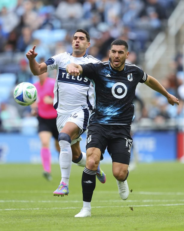 Vancouver Whitecaps forward Daniel Ríos, left, and Minnesota United defender Michael Boxall, right, chase the ball during the first half of an MLS soccer match Sunday, April 27, 2025, in St. Paul, Minn. (AP Photo/Adam Bettcher)