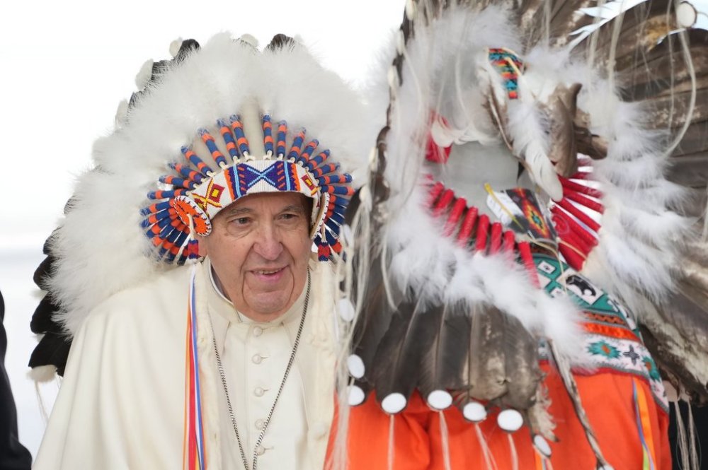 Pope Francis wears a traditional headdress he was given after his apology to Indigenous people during a ceremony in Maskwacis, Alta., as part of his papal visit across Canada on Monday, July 25, 2022. THE CANADIAN PRESS/Nathan Denette