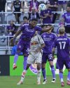 Orlando City defender Alex Freeman (30) gets an advantage on a head ball in front of New York Red Bulls forward Eric Maxim Choupo-Moting during the first half of an MLS soccer match, Saturday, April 12, 2025, in Orlando, Fla. (AP Photo/John Raoux)