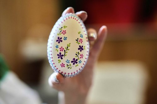 Janine Massnick, a woman of Germany's Slavic-speaking Sorbian ethnic minority, shows a traditional decorated Easter Egg at a Easter Market in Schleife, Germany, Sunday, April 6, 2025. (AP Photo/Markus Schreiber)