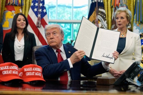 President Donald Trump holds a signed executive order relating to Historically Black Colleges and Universities in the Oval Office of the White House, Wednesday, April 23, 2025, in Washington. (AP Photo/Alex Brandon)