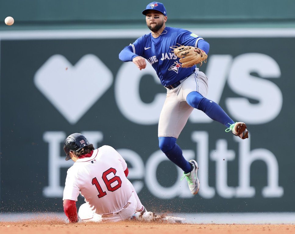 Toronto Blue Jays shortstop Bo Bichette, top, throws to first base over Boston Red Sox's Jarren Duran (16) to complete a double play in the third inning of a baseball game Thursday, April 10, 2025, in Boston. (AP Photo/Jim Davis)