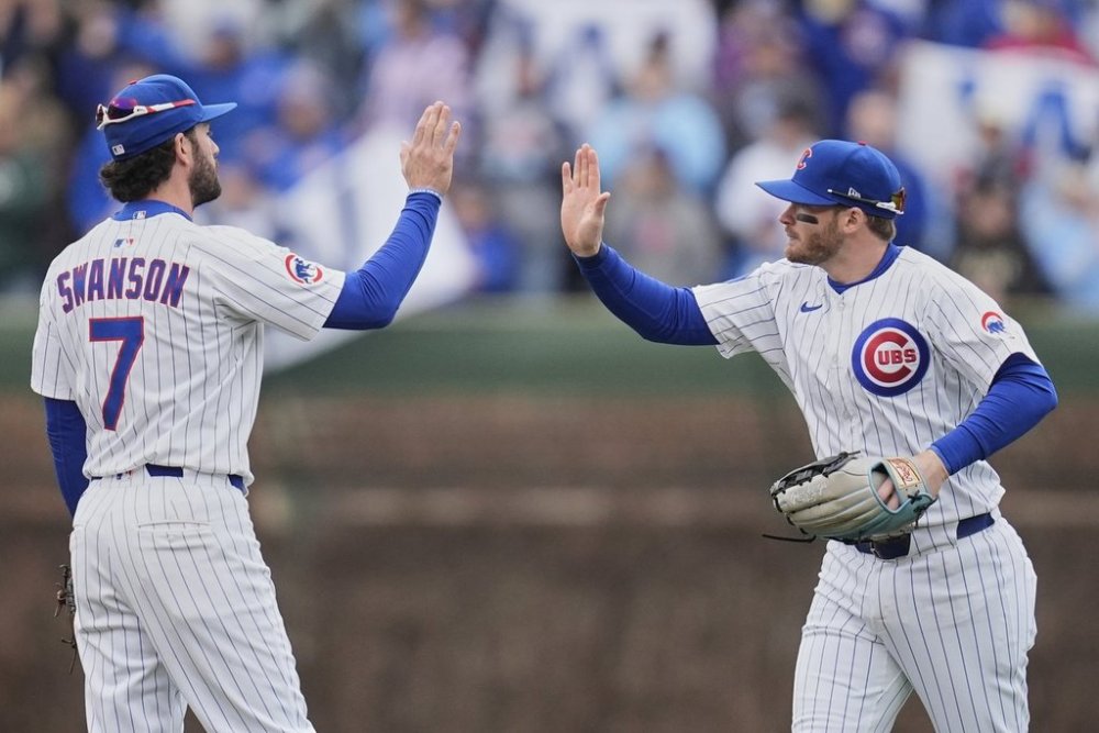 Chicago Cubs' Dansby Swanson (7), left, and Ian Happ (8) celebrate their team's win over the Arizona Diamondbacks in a baseball game Saturday, April 19, 2025, in Chicago. (AP Photo/Erin Hooley)