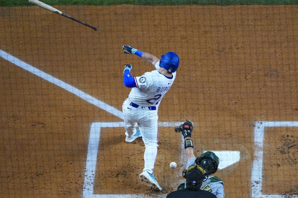 Texas Rangers' Jake Burger loses his bat while swinging at a pitch from Oakland Athletics starting pitcher Luis Severino during the first inning of a baseball game Wednesday, April 30, 2025, in Arlington, TX. (AP Photo/Julio Cortez)