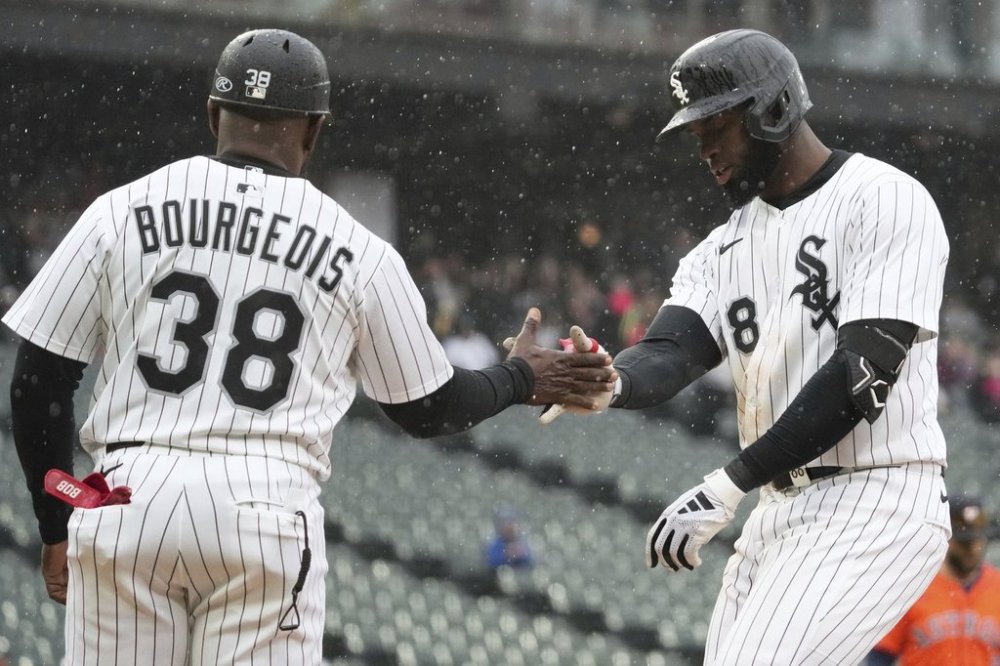 Chicago White Sox's Luis Robert Jr., right, celebrates with first base coach Jason Bourgeois (38) after hitting a one-run single during the sixth inning of a baseball game against the Houston Astros in Chicago, Sunday, May 4, 2025. (AP Photo/Nam Y. Huh)