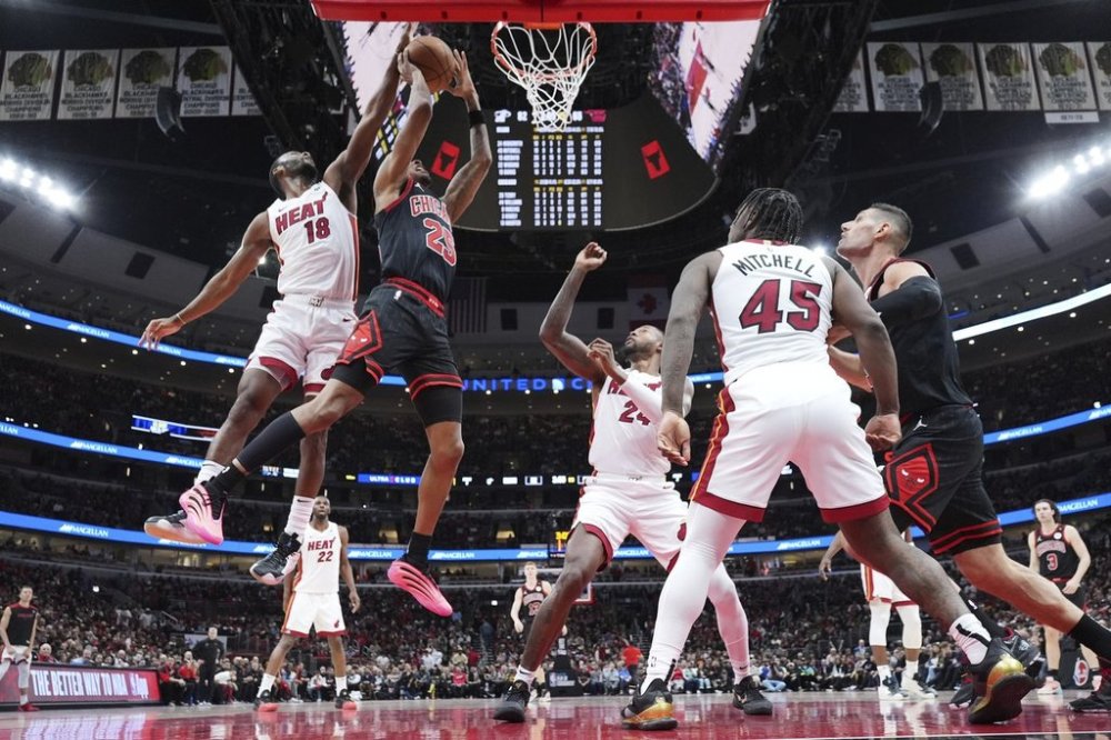 Chicago Bulls forward Dalen Terry, second from left, drives to the basket past Miami Heat guard Alec Burks, left, during the second half of an NBA play-in tournament basketball game in Chicago, Wednesday, April 16, 2025. (AP Photo/Nam Y. Huh)