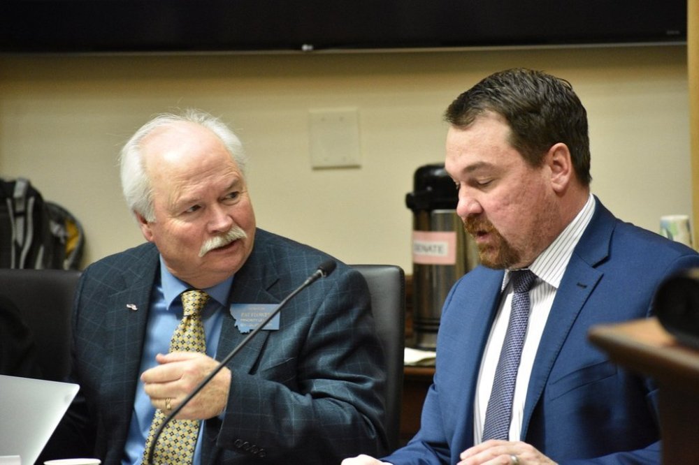 Montana Democratic Minority Leader Sen. Pat Flowers, left, speaks with Republican Sen. Josh Kassmier during a committee meeting at the state Capitol, April 16, 2025, in Helena, Mont. (AP Photo/Matthew Brown)