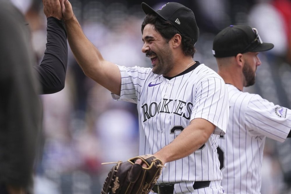 Colorado Rockies relief pitcher Zach Agnos is congratulated after a baseball game against the Atlanta Braves Wednesday, April 30, 2025, in Denver. (AP Photo/David Zalubowski)