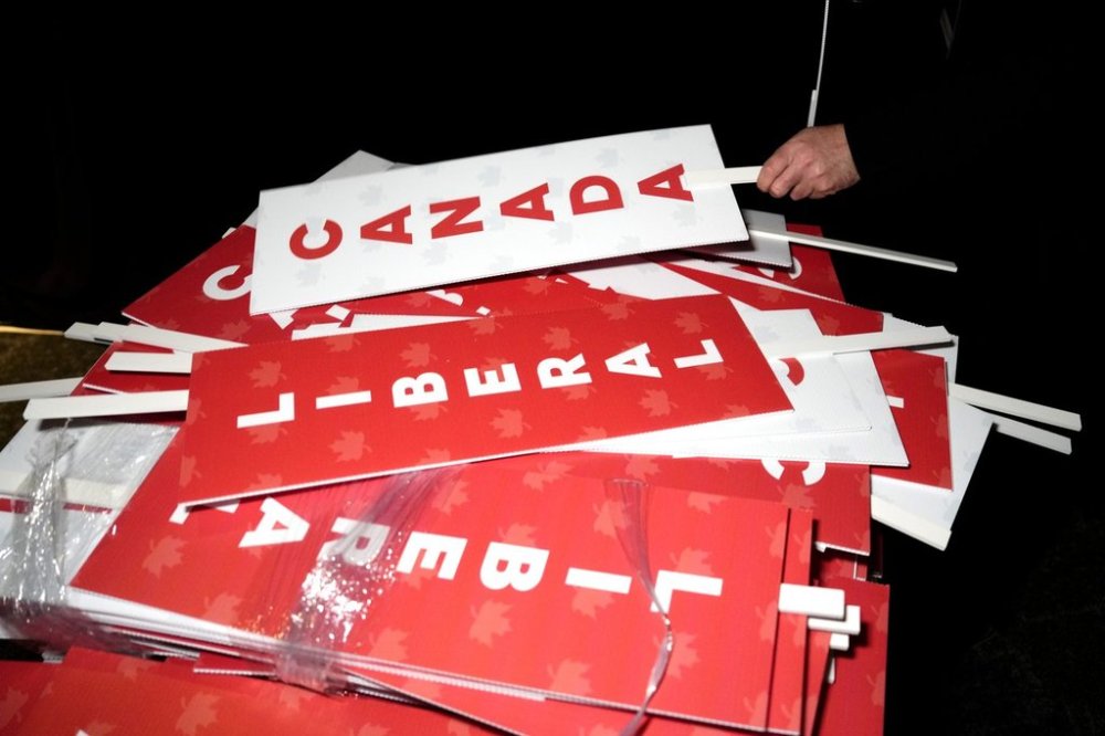 A person picks up a sign at the Liberal leadership event in Ottawa on March 9, 2025. THE CANADIAN PRESS/Justin Tang