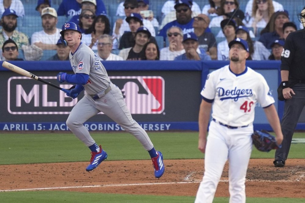 Chicago Cubs' Pete Crow-Armstrong, left, heads to first for a solo home run as Los Angeles Dodgers relief pitcher Blake Treinen watches during the seventh inning of a baseball game Sunday, April 13, 2025, in Los Angeles. (AP Photo/Mark J. Terrill)