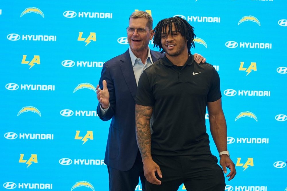 Los Angeles Chargers head coach Jim Harbaugh, left, introduces running back Omarion Hampton, the Chargers first round draft pick, No. 22 overall, during an NFL football news conference at The Bolt in El Segundo, Calif., Friday, April 25, 2025. (AP Photo/Damian Dovarganes)