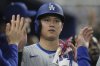 Los Angeles Dodgers' Shohei Ohtani celebrates after scoring on a home run by Freddie Freeman during the third inning of a baseball game against the Miami Marlins, Monday, May 5, 2025, in Miami. (AP Photo/Marta Lavandier)