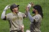 San Diego Padres' Manny Machado, left, celebrates with Fernando Tatis Jr. as he returns to the dugout after hitting a solo home run off Pittsburgh Pirates pitcher Bailey Falter during the seventh inning of a baseball game in Pittsburgh, Saturday, May 3, 2025. (AP Photo/Gene J. Puskar)