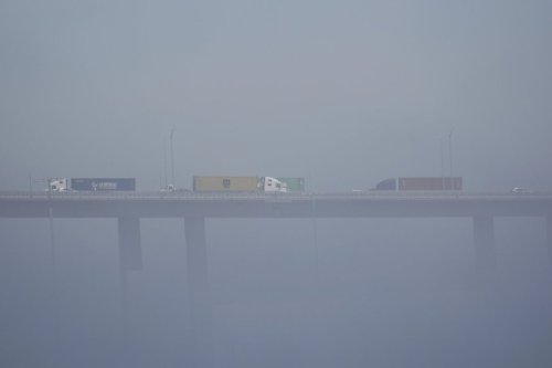 FILE - Trucks carrying shipping containers cross the Long Beach International Gateway Bridge at the Port of Long Beach, Calif., April 8, 2025. (AP Photo/Damian Dovarganes, File)