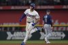Texas Rangers' Wyatt Langford runs the bases past Tampa Bay Rays second baseman Brandon Lowe (8) after hitting a home run during the seventh inning of a baseball game Saturday, April 5, 2025, in Arlington, Texas. (AP Photo/LM Otero)