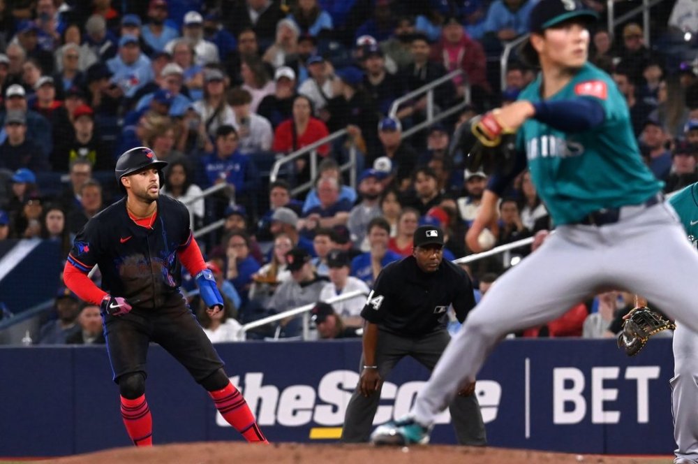 Toronto Blue Jays' George Springer (4) takes a lead off first base as Seattle Mariners starting pitcher Bryan Woo (22) throws to a Blue Jays batter in second inning MLB baseball action in Toronto on Friday, April 18, 2025. THE CANADIAN PRESS/Jon Blacker