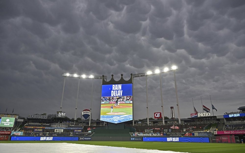 Dark skies cover Kauffamn Stadium during a rain delay of a baseball game between the Kansas City Royals and Colorado Rockies Wednesday, April 23, 2025, in Kansas City, Mo. (AP Photo/Peter Aiken)