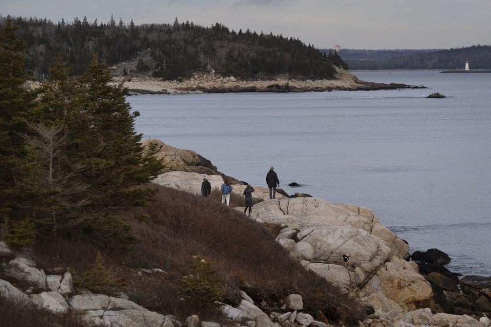 People hike along the rocky coastline at Herring Cove Provincial Park as the mouth of Halifax harbour is seen in the background in Halifax, Tuesday, Dec. 26, 2023. THE CANADIAN PRESS/Darren Calabrese