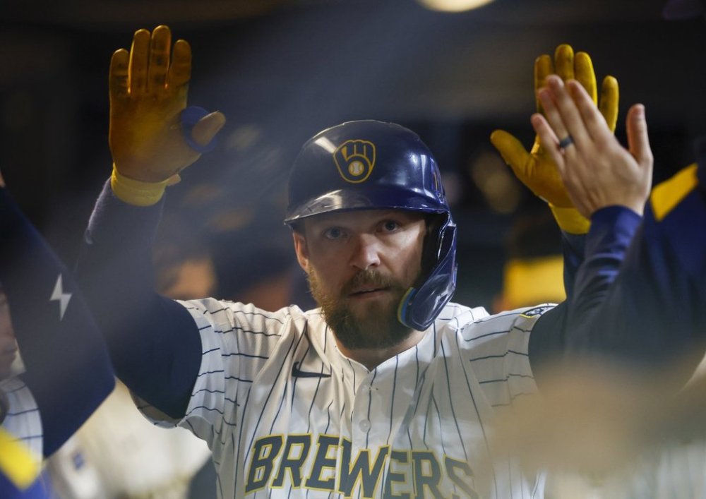 Milwaukee Brewers' Rhys Hoskins receives high-fives in the dugout after his home run against the Athletics during the third inning of a baseball game, Sunday, April 20, 2025, in Milwaukee. (AP Photo/Jeffrey Phelps)