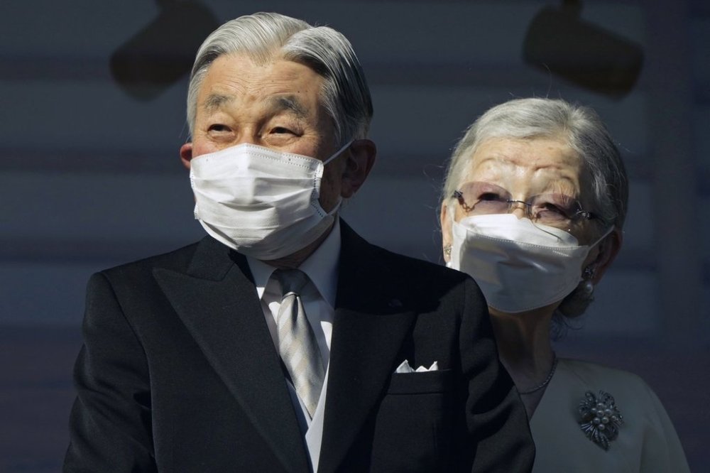 FILE - Japan's Emperor Emeritus Akihito and Empress Emerita Michiko greet well-wishers through a bullet-proof glass from a balcony during their New Year's public appearance at the Imperial Palace in Tokyo, Jan. 2, 2023. (Franck Robichon/Pool Photo via AP, File)